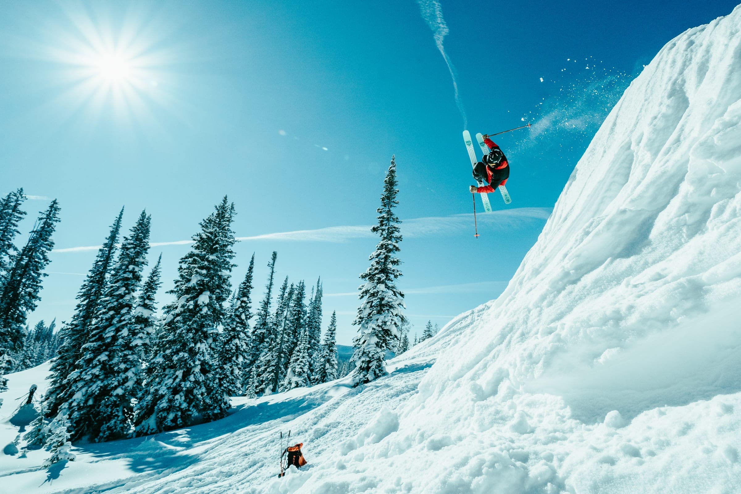 Snowboarder framed against a sunstar and cornice